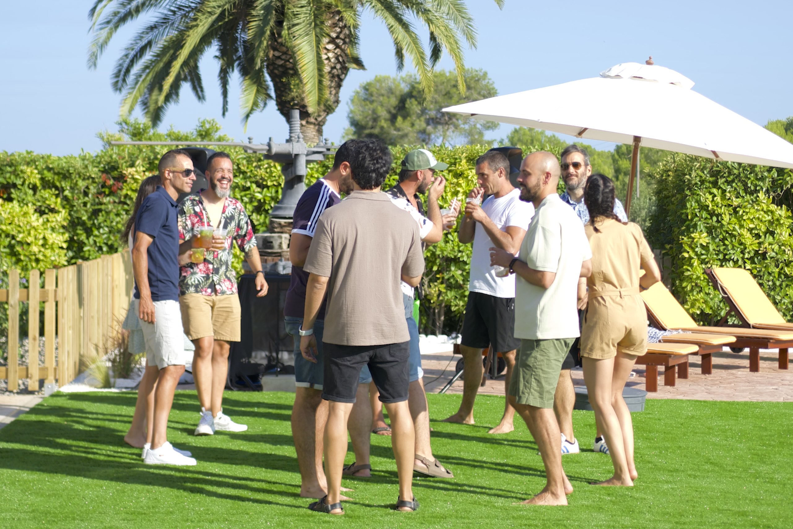 Un grup d’amics gaudint d’una trobada a l’aire lliure al jardí de la Masia L’Encís