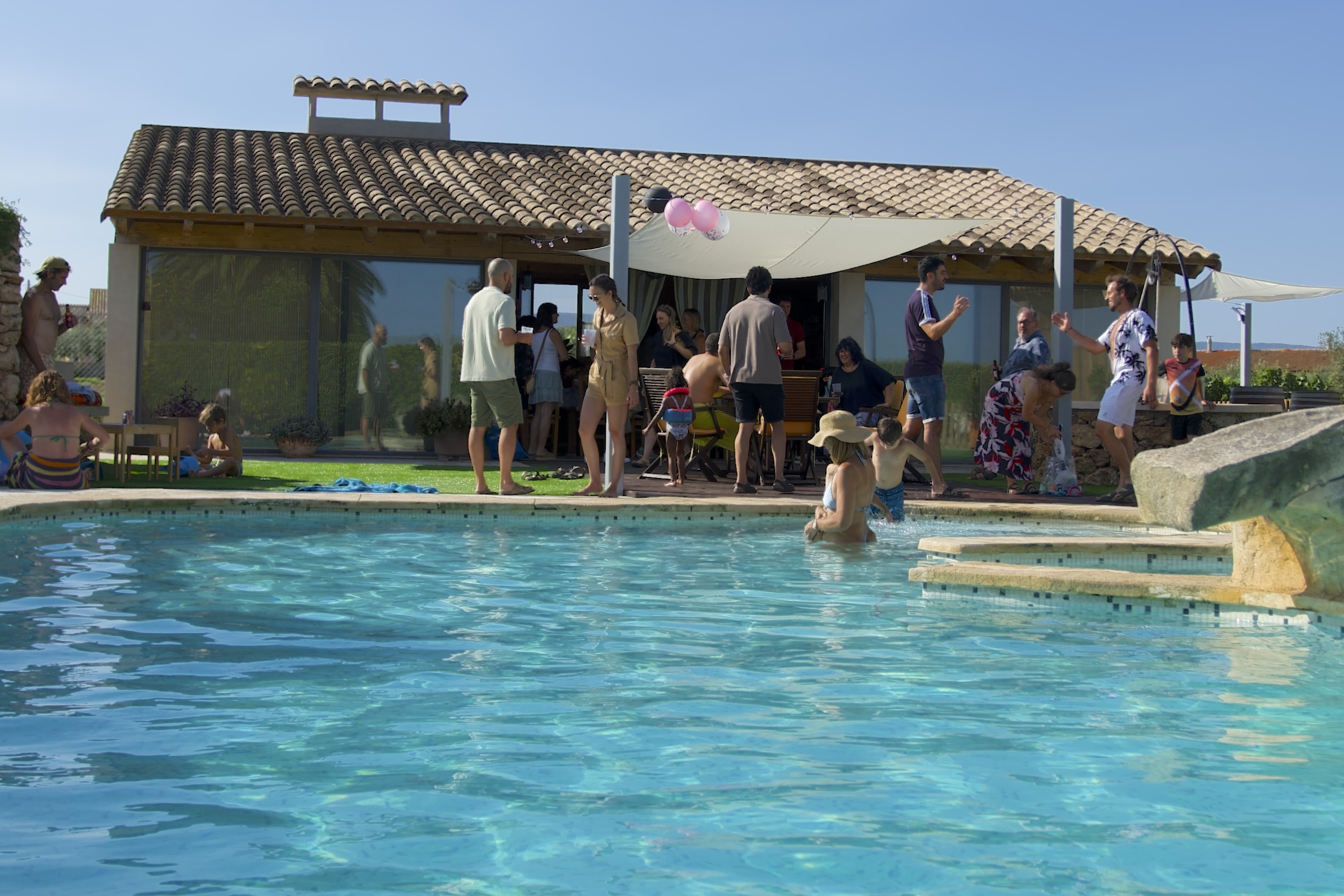 Famílies i amics gaudint d’una festa a la piscina de la Masia L’Encís
