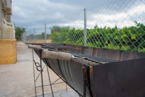Barbacoa exterior metàl·lica amb graella i utensilis a la Masia L’Encís