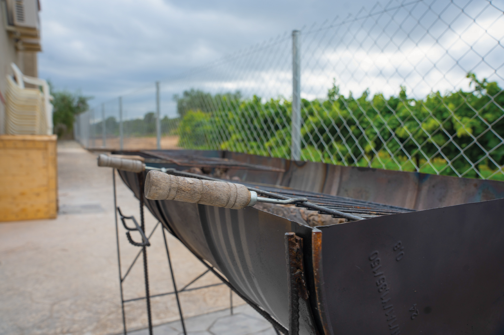 Barbacoa exterior metàl·lica amb graella i utensilis a la Masia L’Encís