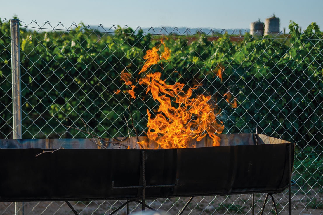 Barbacoa encesa amb foc viu a l’exterior de Masia L’Encís, ideal per a trobades i àpats a l’aire lliure